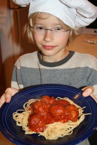 A boy with a plate of spaghetti
