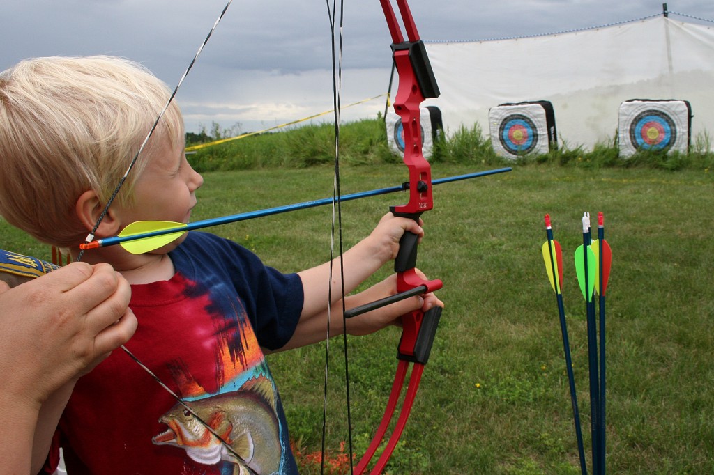 Little boy shooting bow and arrow