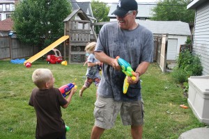 Kids playing water guns with Grandpa