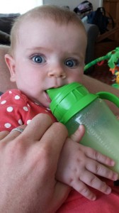 baby drinking breastmilk from sippy cup